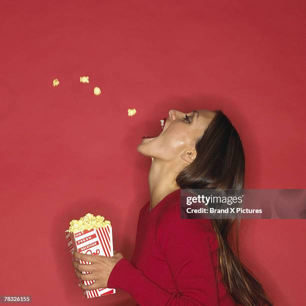 woman catching popcorn with her mouth - catching food stock pictures, royalty-free photos & images