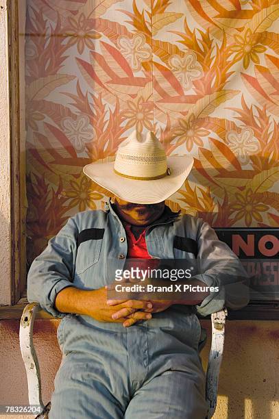 napping man in cowboy hat - cowboy sleeping stock-fotos und bilder