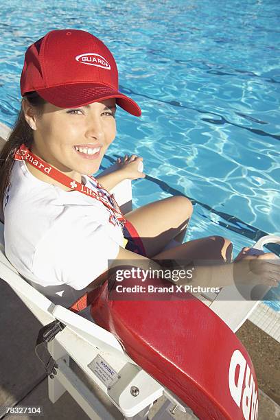 lifeguard sitting in chair at swimming pool - lifeguard fotografías e imágenes de stock