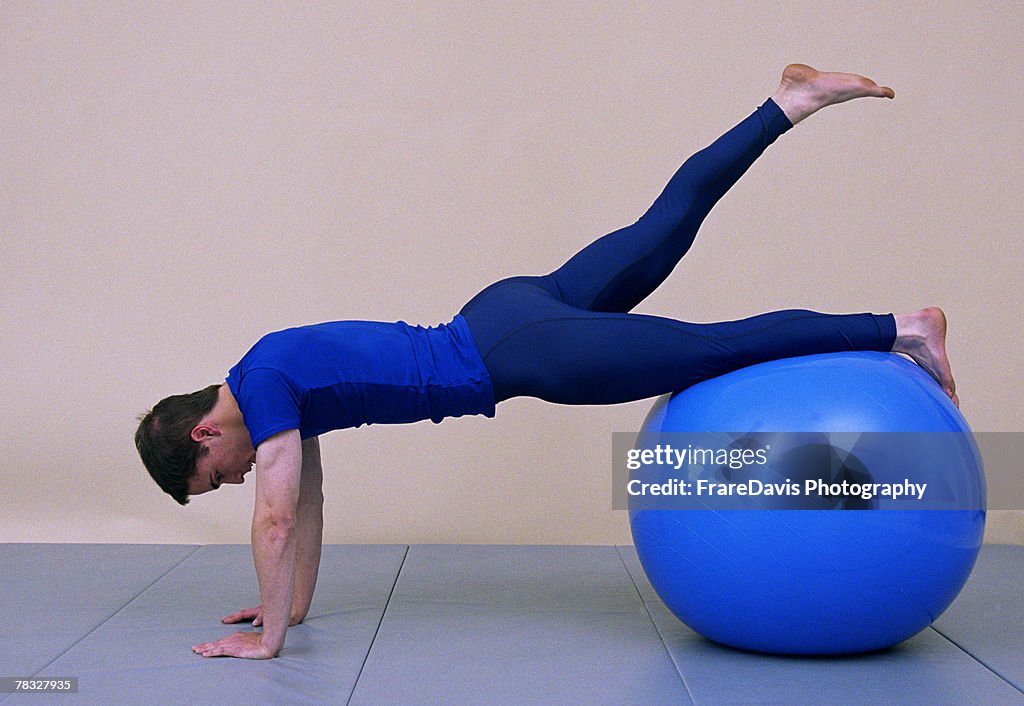 Man stretching on exercise ball