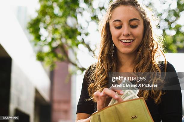 teen removing money from wallet - wallet money stock pictures, royalty-free photos & images