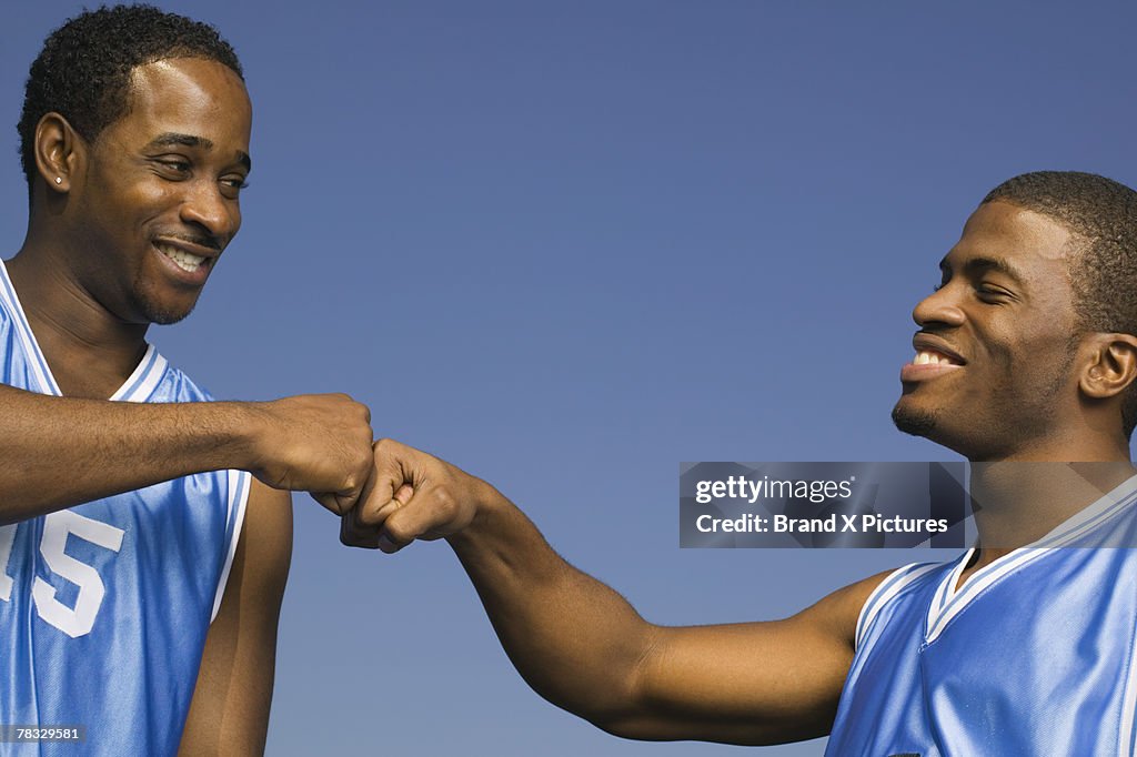 Basketball players fist bumping