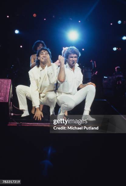 Andrew Ridgeley and George Michael of Wham! performing during the pop duo's 1985 world tour in January 1985. In the background are backing singers...