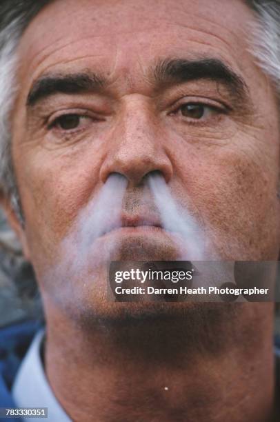 Portrait of Flavio Briatore, team principal for the Mild Seven Benetton Playlife F1 Team as he smokes a cigarette during the Formula One European...