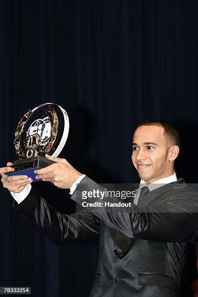 In this handout image provided by FIA, Formula One Driver Lewis Hamilton of Britain and Team McLaren-Mercedes holds a FIA trophy during the 2007 FIA...