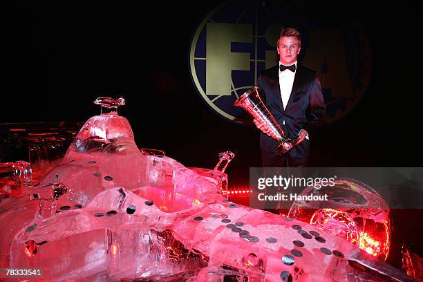 In this handout image provided by FIA, FIA Formula One World Champion Kimi Raikkonen of Finland and Ferrari poses next to an ice sculpture with the...