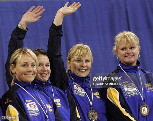 The Swedish women's curling team Annette Norberg, Eva Lund, Catherine Lindahl and Anna Svard celebrate with their medals after defeating Scotland in...