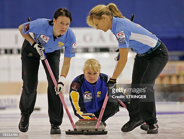 Sweden's Annette Norberg releases the stone as Catherine Lindahl and Anna Svard follow up on the throw on their way to defeating Scotland in the...