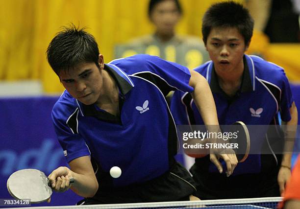 Malaysian table tennis player Ibahim Muhd Shakirin hits a return as his partner Chai Kian Beng gets ready during the mens doubles semi final of the...