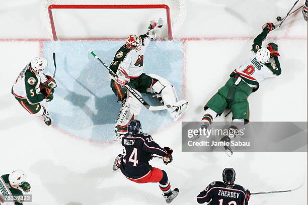 Niklas Backstrom and Brent Burns of the Minnesota Wild go down on the ice to keep Rick Nash of the Columbus Blue Jackets from scoring as Kim Johnsson...