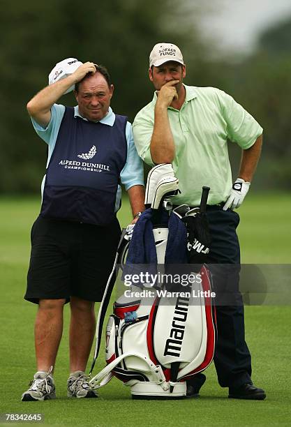 John Bickerton of England waits with his caddie to play his second shot into the second green during the final round of The Alfred Dunhill...