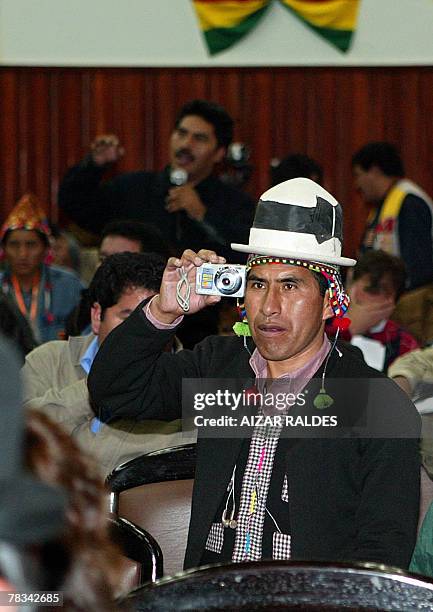 Member of the Constituent Assembly takes pictures during the discussion of an article of the new Bolivian constitution on December 09, 2007 in the...