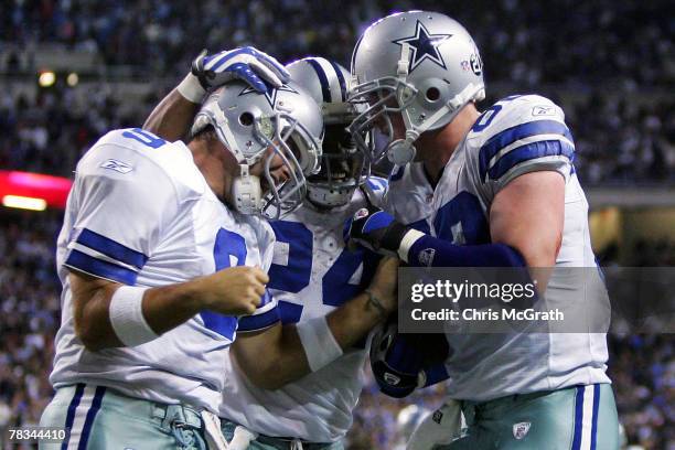 Quarterback Tony Romo and Marion Barber of the Dallas Cowboys congratulate teammate Jason Witten after he scored the winning touchdown against the...