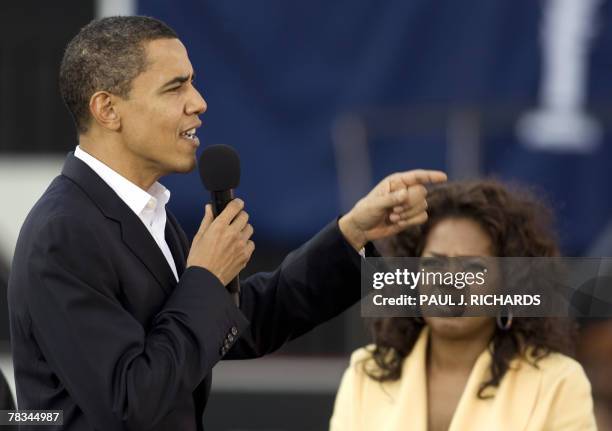 Television host Oprah Winfrey listens as Illinois Senator and Democratic presidential hopeful Barack Obama addresses a campaign event 09 December...