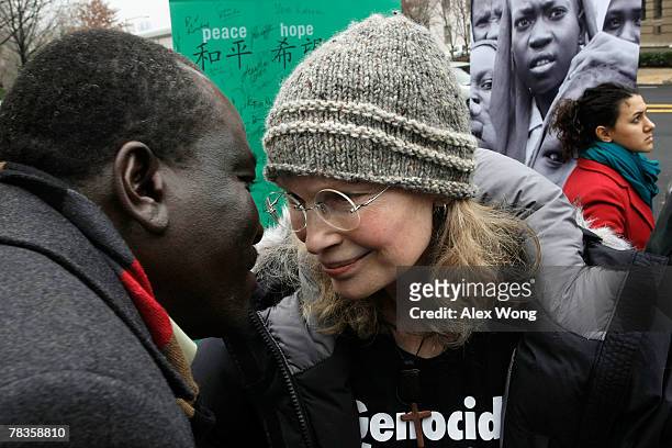 Actress Mia Farrow greets Ali Dinar of Darfur Alert Coalition as she stands in front of a photo that she took near the Darfur broder in Eastern Chad...