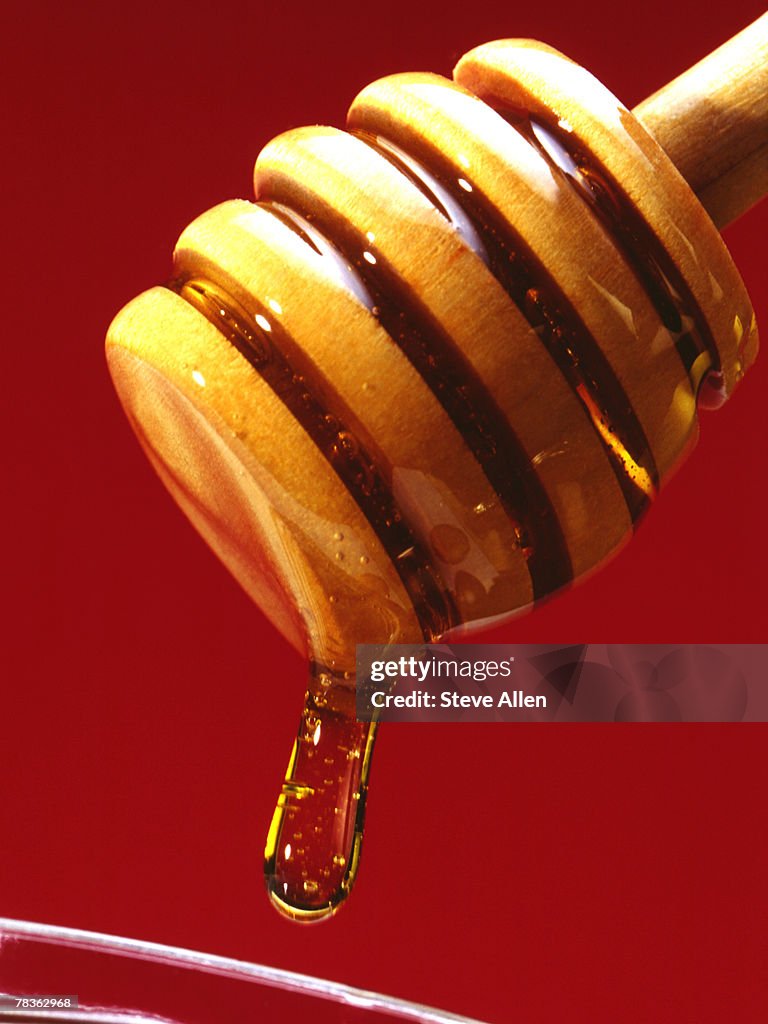 Honey dripping into jar