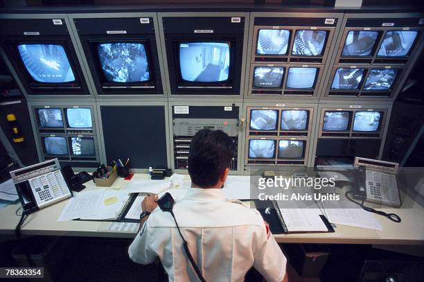 security officer watching television monitors - security camera stock pictures, royalty-free photos & images