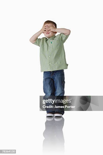 boy hiding behind hands - hidw and seek stock pictures, royalty-free photos & images