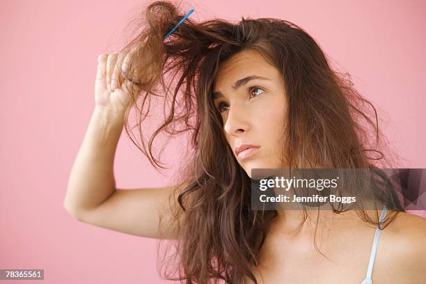 woman combing knotted hair - brushing hair stock pictures, royalty-free photos & images