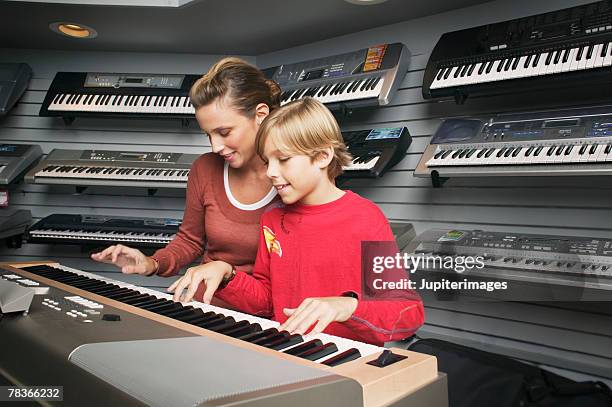 woman and boy playing keyboard together - music shop stock pictures, royalty-free photos & images