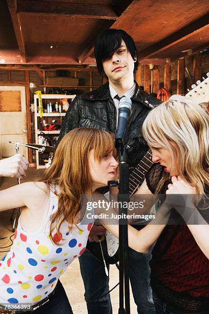 women in band fighting over man - fist clenched by side stock pictures, royalty-free photos & images