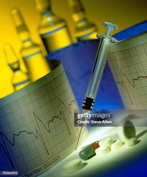 syringe with pills and graph - ecg graph stockfoto's en -beelden