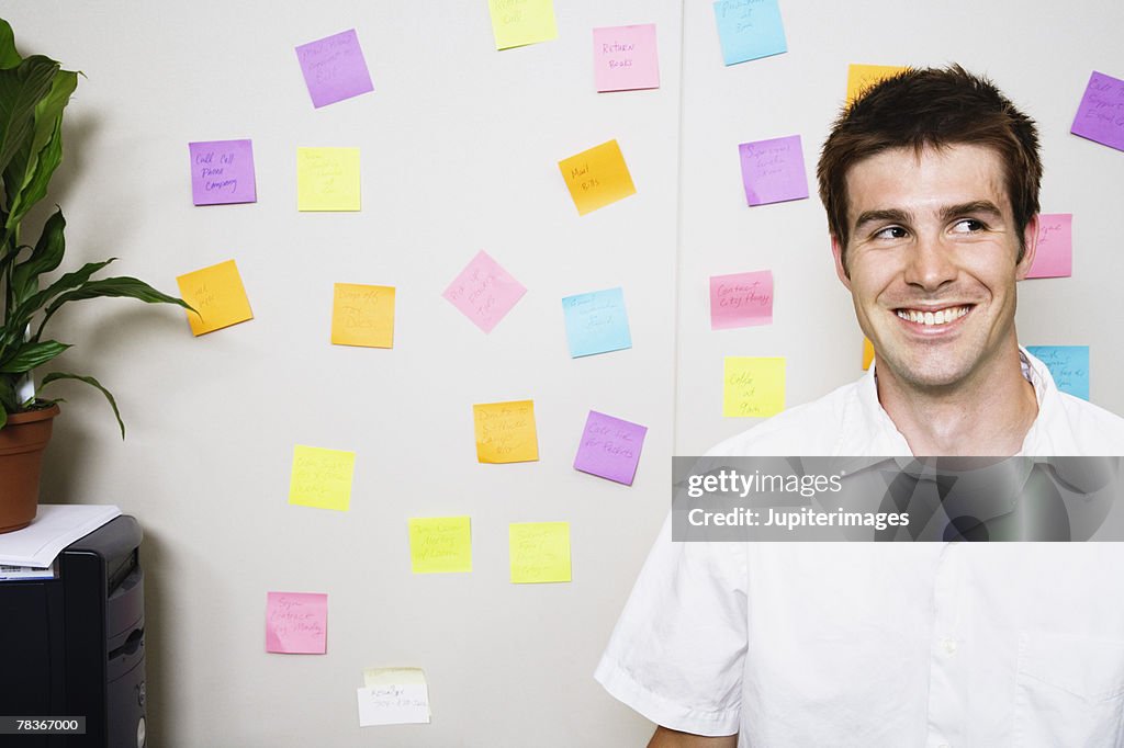 Smiling man in front of wall with sticky notes