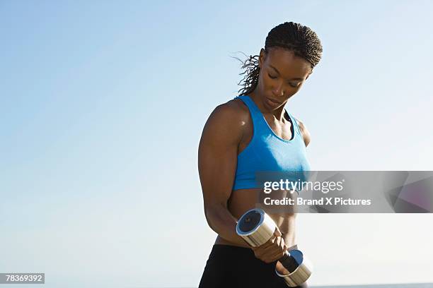 woman with a dumbbell - musculation des biceps photos et images de collection