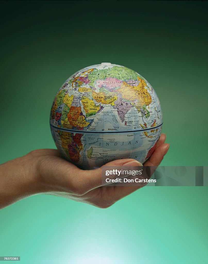 Hand holding globe