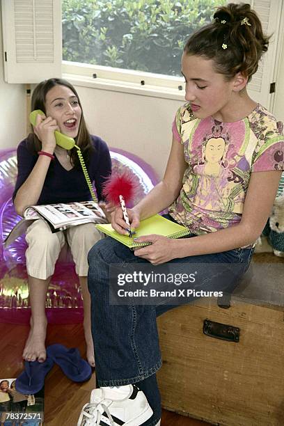 girls doing homework and talking on telephone - bubble chair stock pictures, royalty-free photos & images