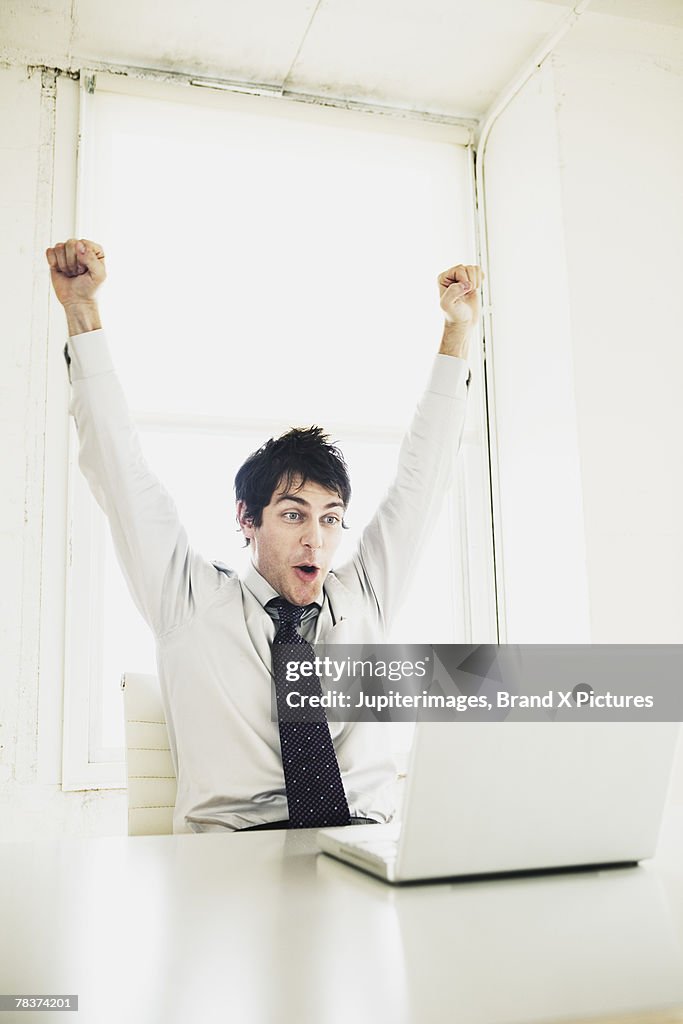 Excited businessman looking at computer