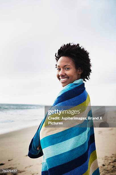 mid-adult woman wrapped in towel on beach - envuelto en una toalla fotografías e imágenes de stock