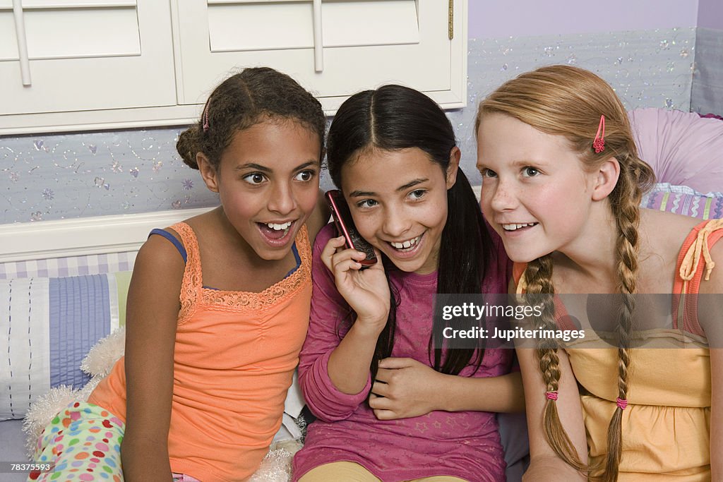 Preteen girls gossiping with cell phone