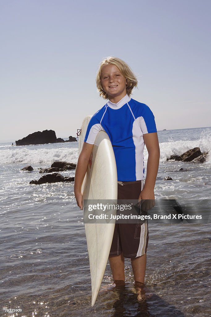 Pre-teen boy with surfboard