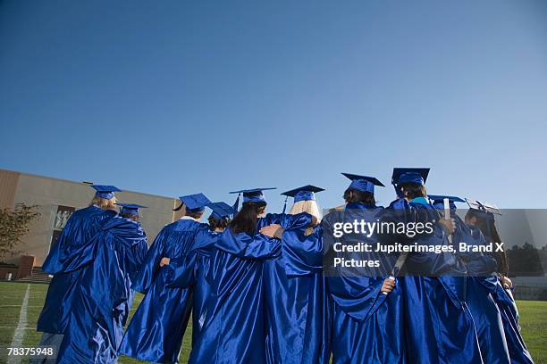 back view of teenagers wearing cap and gowns - secondary school certificate stock pictures, royalty-free photos & images