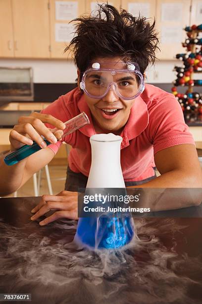 teenage boy performing science experiment - inventor fotografías e imágenes de stock