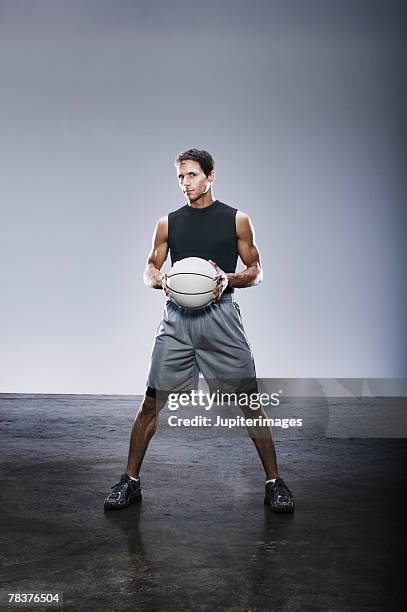 young adult man holding basketball - basketball portrait stockfoto's en -beelden