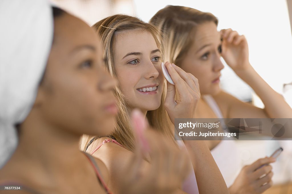 Teenage girls applying makeup