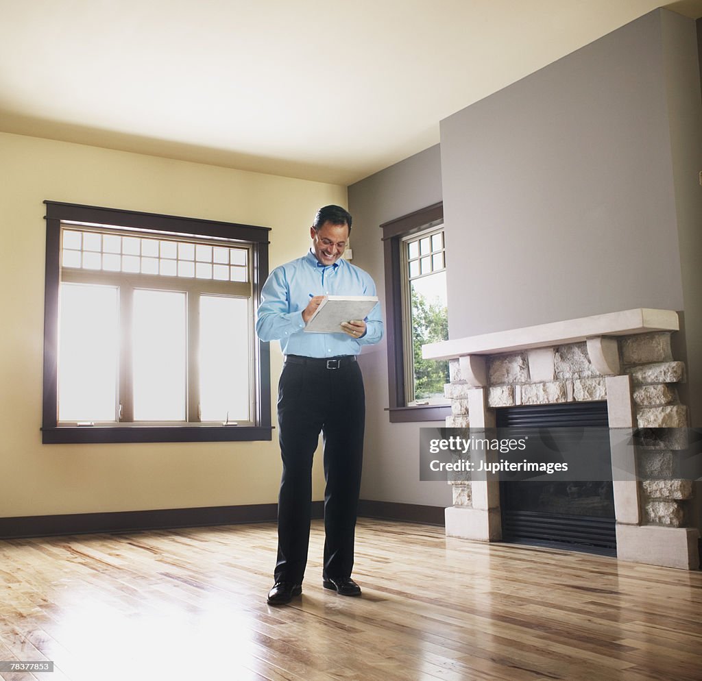 Man taking notes in empty house