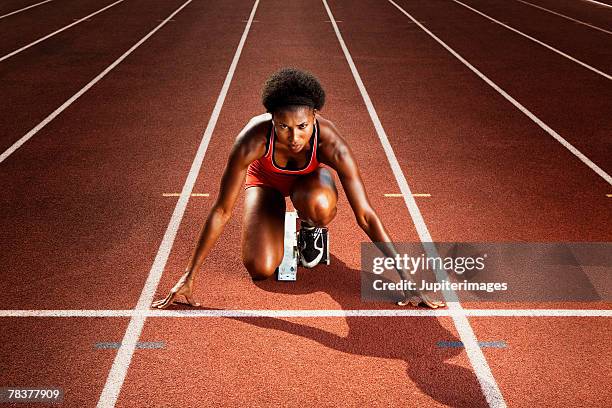 athletic woman preparing for race - starting block stockfoto's en -beelden