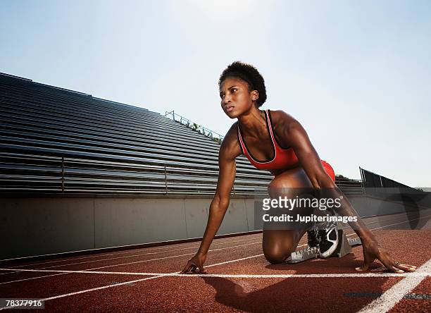 athletic woman preparing for race - posizione sportiva foto e immagini stock