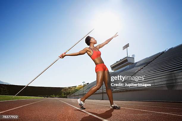 athletic woman throwing a javelin - lancer du javelot photos et images de collection