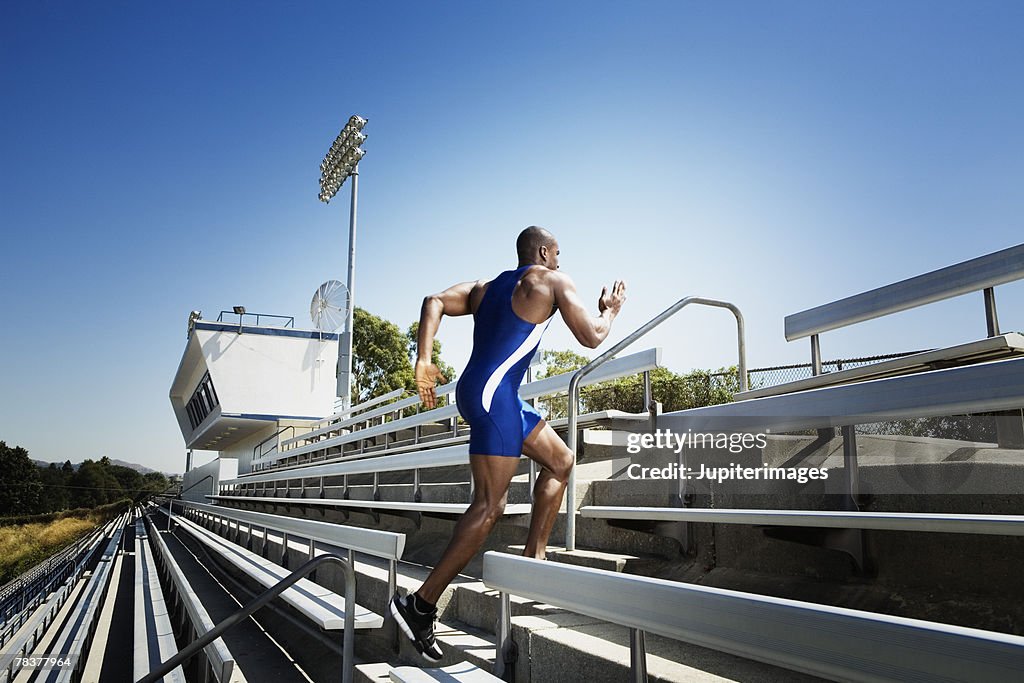 Athletic man running up bleachers