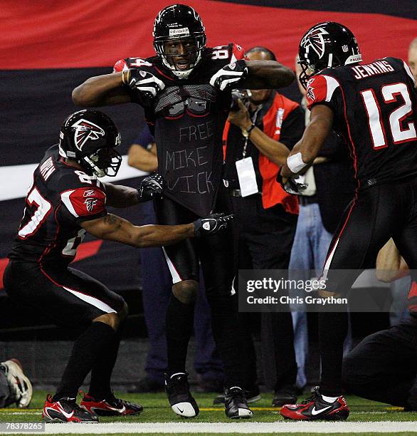 Roddy White celebrates after a touchdown with a t-shirt that reads "Free Mike Vick" with Joe Horn and Michael Jenkins of the Atlanta Falcons against...