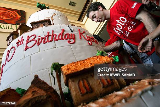 Greenpeace activists slice pieces of a cake after Japanese Environment Minister Ichiro Kamoshita cut it to mark the 10-year-anniversary of the Kyoto...