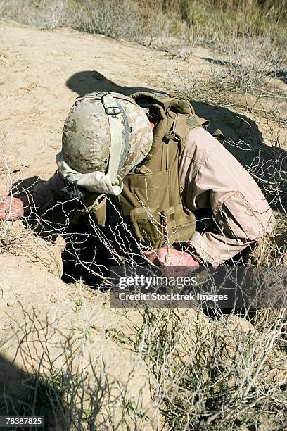 A Soldier Jumps Down A Hole In Search For A Weapons Cache, Foto de stock
