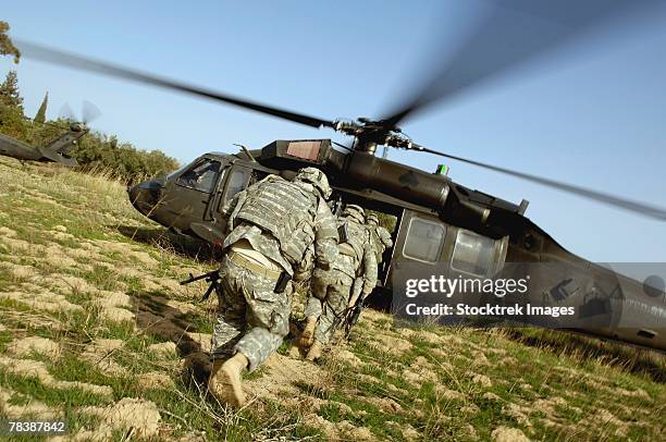 soldiers prepare to board a uh-60 black hawk helicopter. - sikorsky helicopter stock pictures, royalty-free photos & images