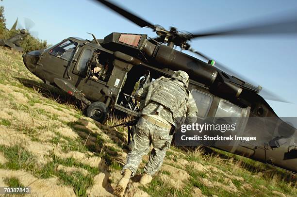 soldiers prepare to board a uh-60 black hawk helicopter. - sikorsky uh 60 black hawk 個照片及圖片檔