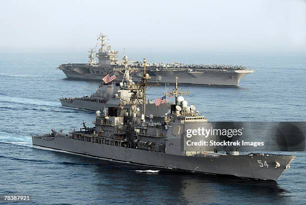 military ships transit through open water. - american flag ocean stock pictures, royalty-free photos & images