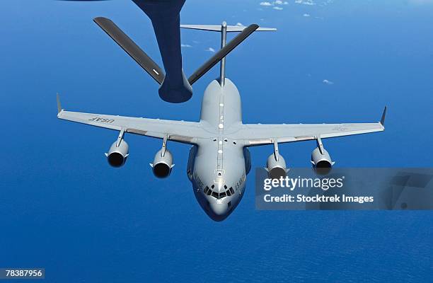 c-17 globemaster approaches a kc-135 stratotanker during aerial refueling. - aerial refueling stock pictures, royalty-free photos & images